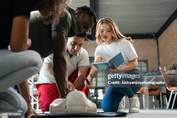 group of students learning cpr - trousse de secours photos et images de collection