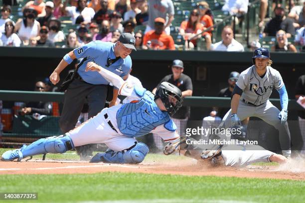 Adley Rutschman of the Baltimore Orioles tags out Brett Phillips of the Tampa Bay Rays at home on a Vidal Brujan hit ball during a baseball game at...
