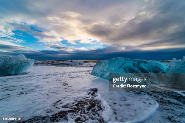 diamond beach near jokulsarlon, filled with washed ashore icebergs from the jokulsarlon glacial lagoon - jökulsárlón lagoon stock-fotos und bilder