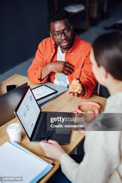 two friends studying together in the library - male student wearing glasses with friends stockfoto's en -beelden