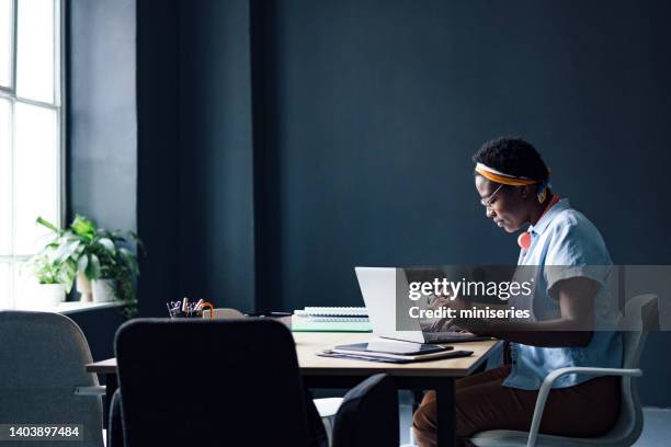 university student working on a school project in the library - toples stockfoto's en -beelden