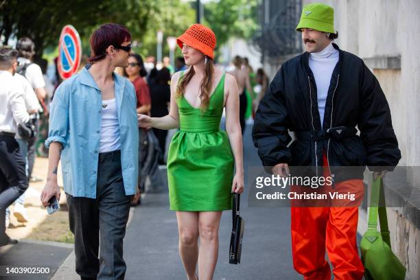 Couple Young Emperors seen wearing green silk dress, orange bucket hat & black belted bomber jacket, green hat, orange pants, bag outside Prada of...