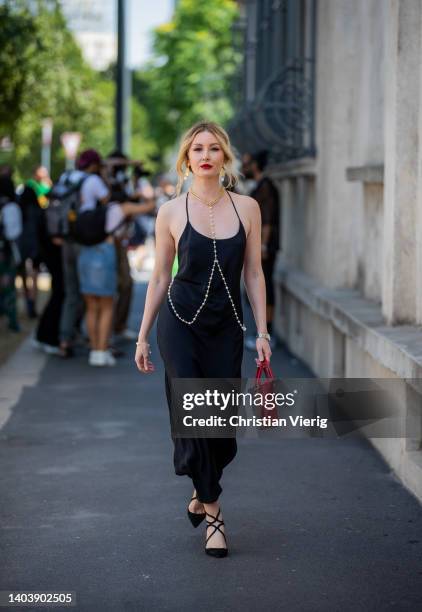 Guest is seen wearing black dress, pearls necklace, burgundy Prada bag outside Prada of during Milan Fashion Week S/S 2023 on June 19, 2022 in Milan,...