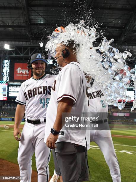 Buddy Kennedy of the Arizona Diamondbacks looks on as his father Buddy Kennedy Sr gets ice water dumped over him after a 7-1 win against the...