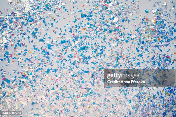 many blue and silver foil confetti on blue background. holiday backdrop. concept of new year coming party. flat lay style - blue confetti stockfoto's en -beelden