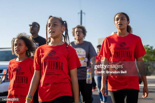 Kelaiah White , leads a group in singing after marching from the Galveston County Courthouse on June 19, 2022 in Galveston, Texas. Galveston island...