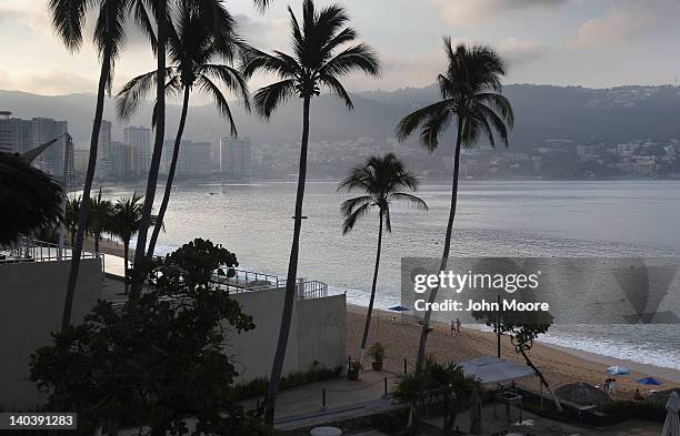 Tourists walk the beach early on March 2, 2012 in Acapulco, Mexico. Drug violence surged in the coastal resort last year, making Acapulco the second...