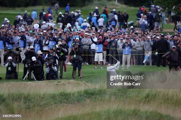Matt Fitzpatrick of England plays a second shot on the 18th hole as media looks on during the final round of the 122nd U.S. Open Championship at The...