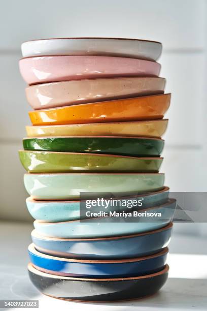 a stack of ceramic plates on a white background. - stack of plates stock pictures, royalty-free photos & images