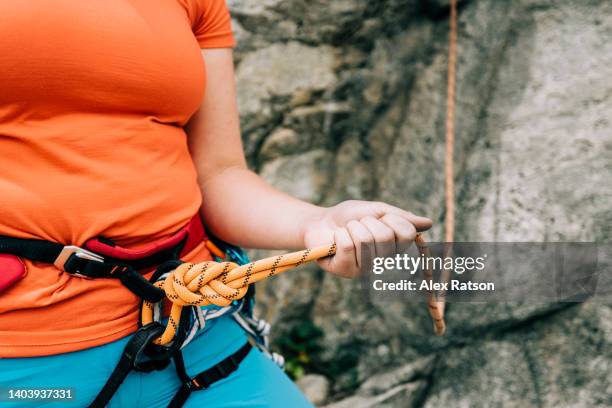 close up of a rock climber tied into a climbing rope with a figure-eight knot - noeud coulant en huit photos et images de collection