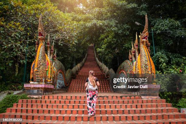 Young woman walking up the stairs of the temple, Doi Suthep in Chiang Mai, Thailand.