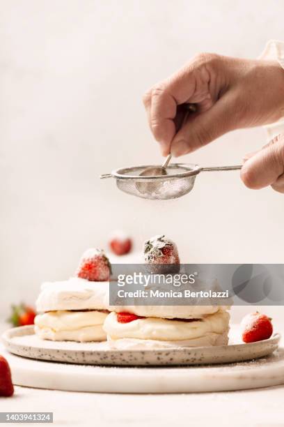 strawberry meringues and whipped cream preparation - powdered sugar sifter fotografías e imágenes de stock