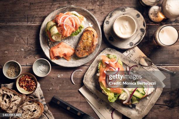 smoked salmon on rye  toast with vegetables and hollandaise sauce, beer glasses - rustic salmon fillets stock pictures, royalty-free photos & images