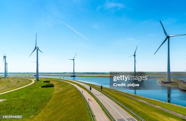 green energy - wind turbines and a dutch road - dyke stockfoto's en -beelden