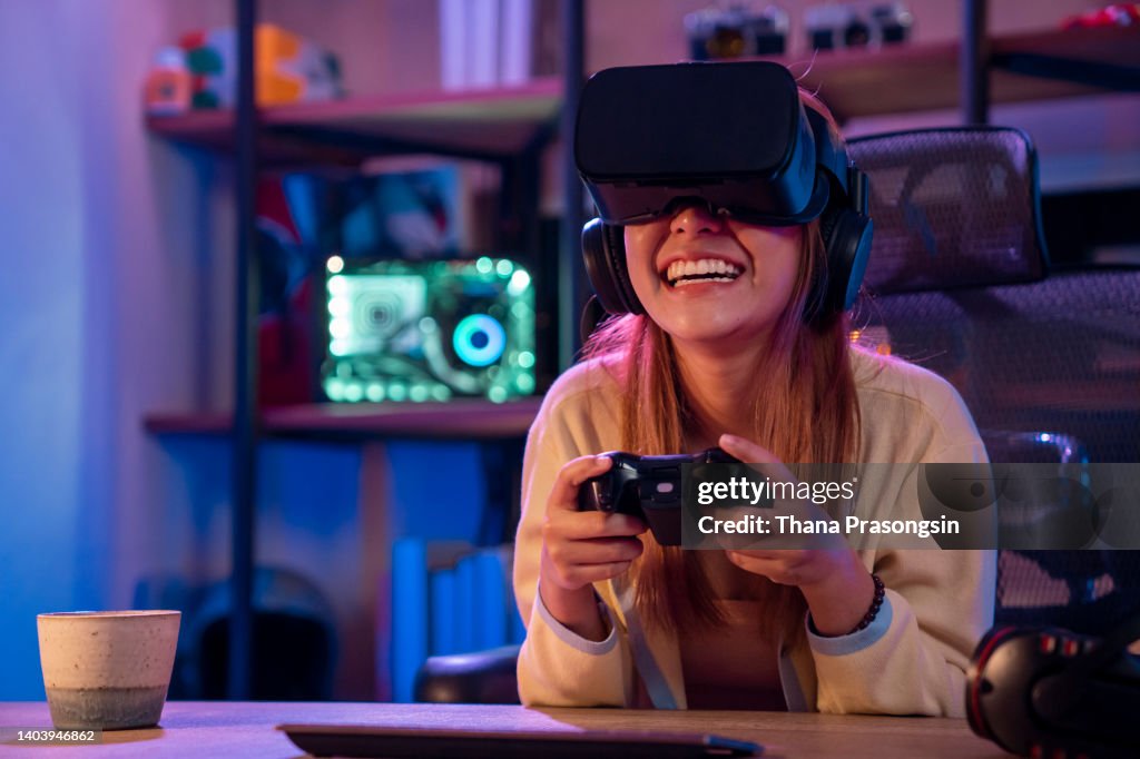 Woman playing a video game with a joystick and VR glasses at home.