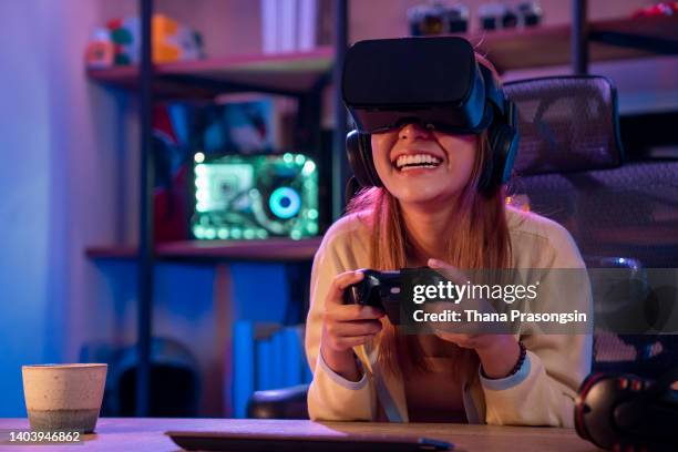 woman playing a video game with a joystick and vr glasses at home. - gamers stockfoto's en -beelden