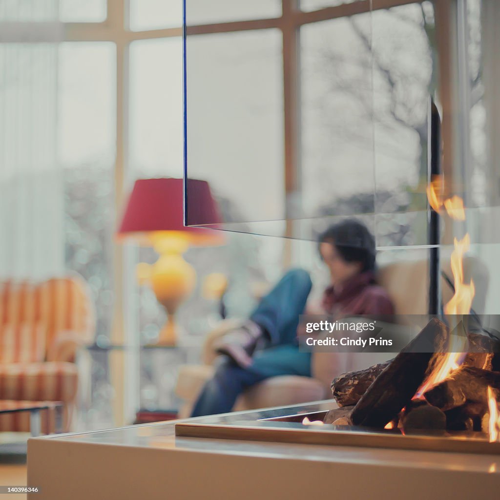 Modern fireplace with boy sitting in chair