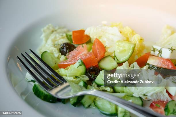 greek salad with feta cheese, olives, juicy tomatoes, red pepper, cucumber and lettuce leaves. the concept of healthy eating. vegetarian and vegan food. natural products from an organic farm. vegetable low-carb diet. - griechischer salat stock-fotos und bilder