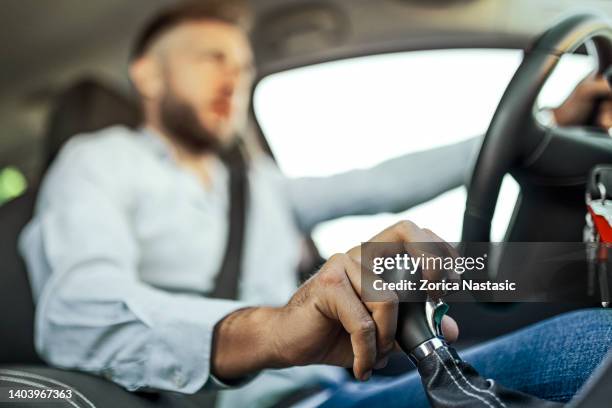 businessman driving to work using gearshift stick - gear shift stockfoto's en -beelden