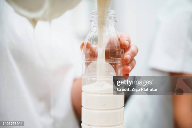 pouring yogurt into an empty bottle - dairy factory stock pictures, royalty-free photos & images