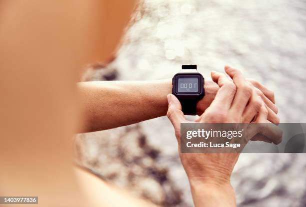 female swimmer prepares for a sea swim in ibiza, spain - wetsuit stock pictures, royalty-free photos & images