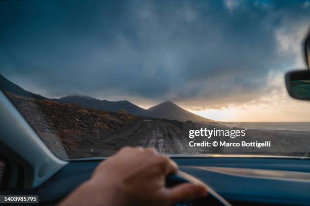 personal perspective of person driving on dirt track under storm - silla-de-conductor fotografías e imágenes de stock
