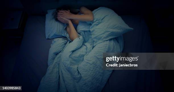 woman in bed can't sleep due to insomnia - aterrorizado imagens e fotografias de stock