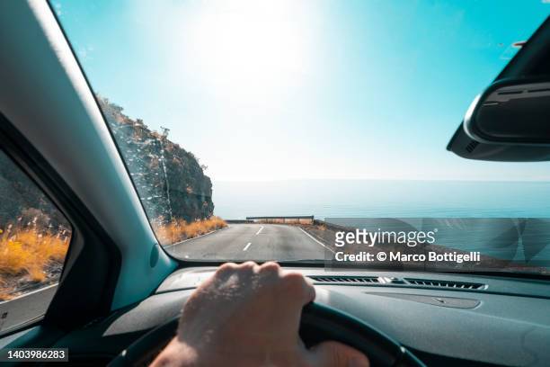 personal perspective of person driving along the coast - förarsäte bildbanksfoton och bilder