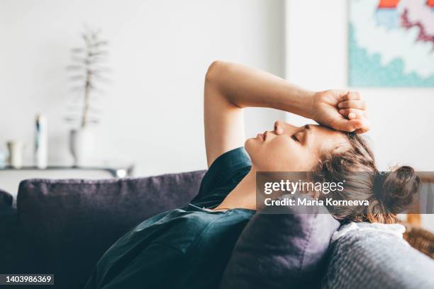 sad and depressed woman sitting on sofa at home. - enfermedad mental fotografías e imágenes de stock