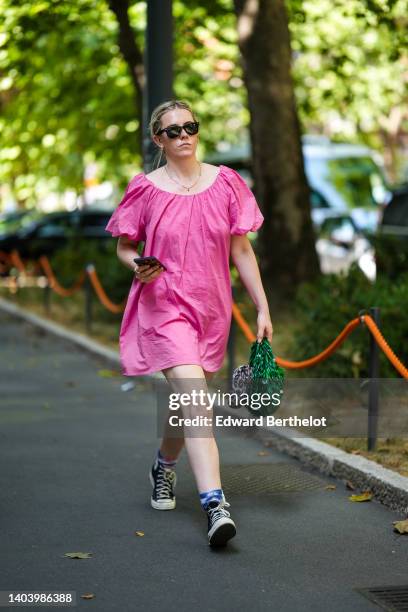 Guest wears black sunglasses, a silver chain necklace, a pink puffy short sleeves short dress, a silver ring, a green pearls handbag, a gray leopard...