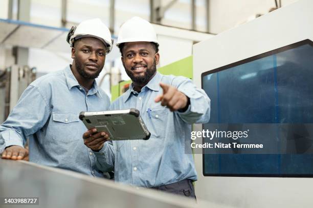 value chain coordination service for manufacturing industry.  an african american manufacturing process engineer and manager having discussion about process control plan of auto parts injection molding in the production line shop floor. - shaping future stock-fotos und bilder