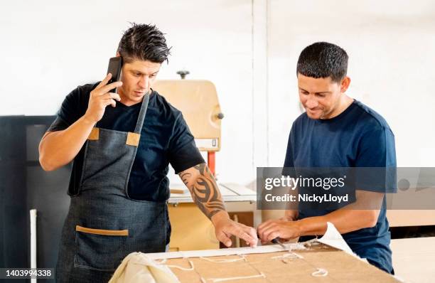 furniture manufacturing business owner talking on phone in workshop - upholstry stockfoto's en -beelden