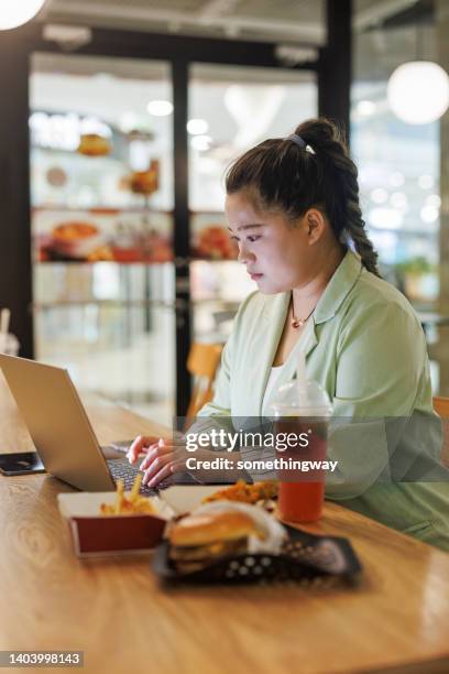 dicke frauen, die in restaurants an laptops arbeiten - fat woman sitting on man stock-fotos und bilder