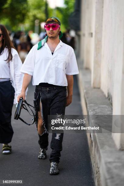 Guest wears a green and gray print pattern silk scarf in the hair, pink large sunglasses, a black tank-top, a white oversized shirt, black ripped...