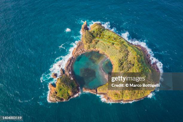 small crater island with round lake, azores, portugal - vulkankrater stock-fotos und bilder