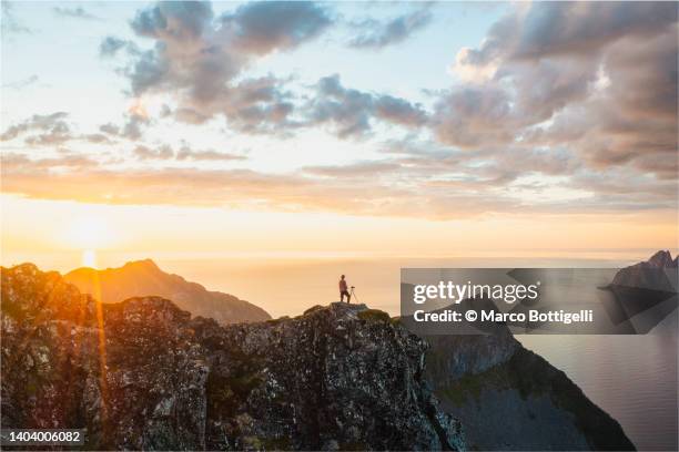 photographer on mountain top above a fjord, norway - senja stockfoto's en -beelden