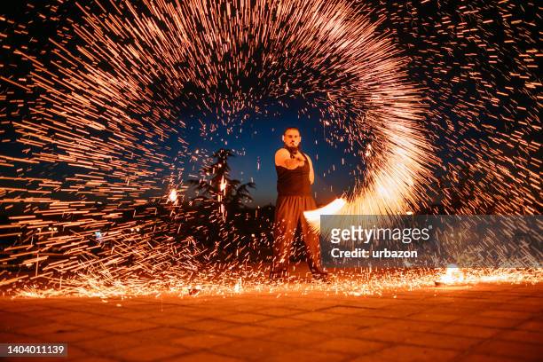 fire juggler performing at night - street performer stock pictures, royalty-free photos & images