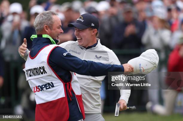 Matthew Fitzpatrick of England celebrates with caddie Billy Foster after winning the 122nd U.S. Open Championship at The Country Club on June 19,...