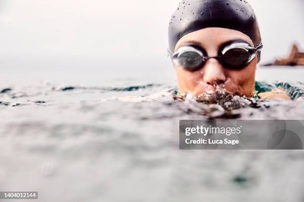 female swimmer in ibiza, wearing goggles and swim cap - open workouts imagens e fotografias de stock