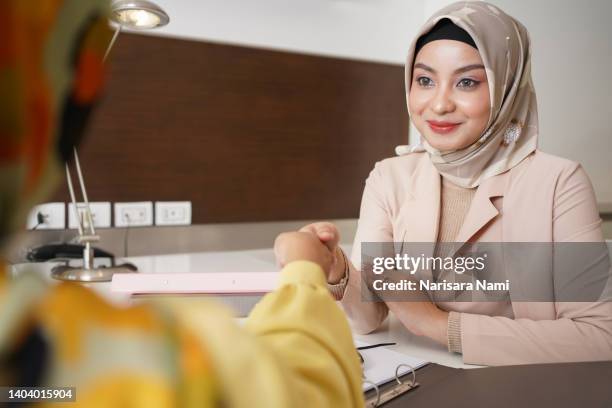 muslim businesswoman shacking hands after successful business agreement. - islamic finance stock pictures, royalty-free photos & images