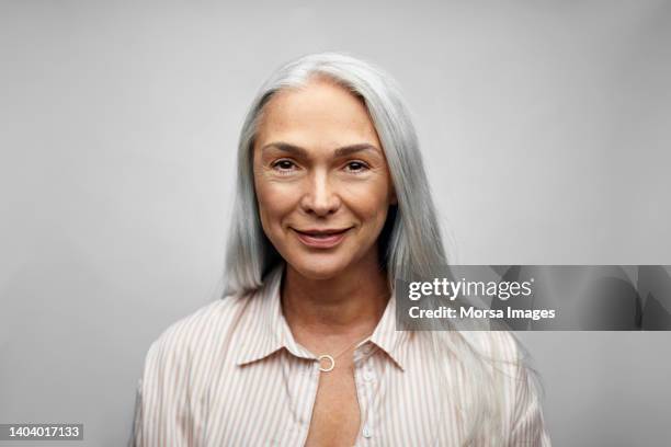 mature businesswoman smiling on white background - canas fotografías e imágenes de stock