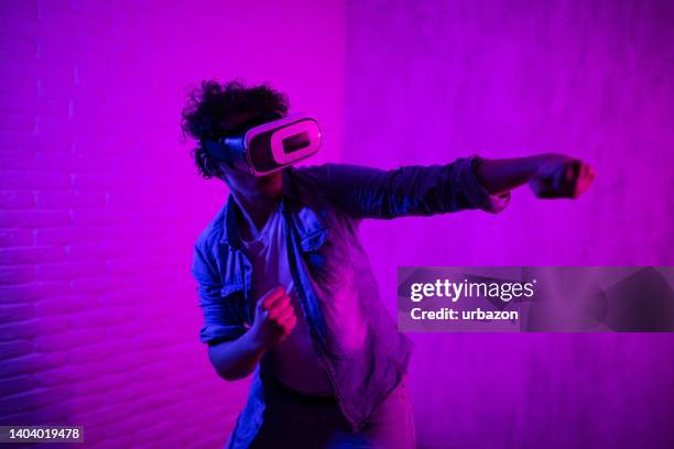 junger mann, der ein virtual-reality-spiel spielt - 360 people stock-fotos und bilder