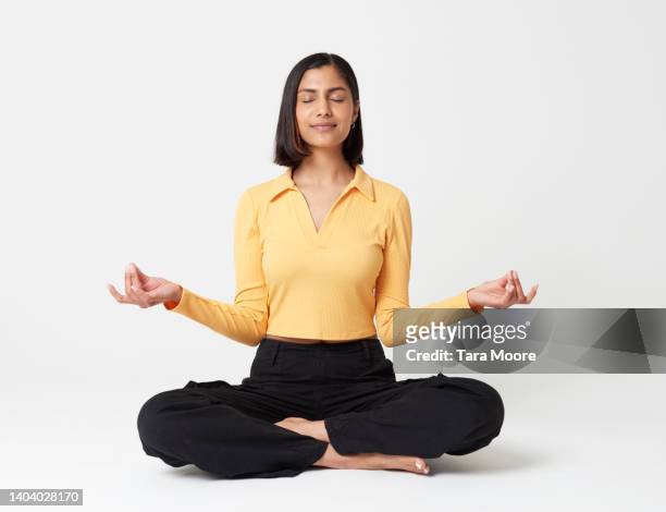 woman meditating - lotuspositie stockfoto's en -beelden