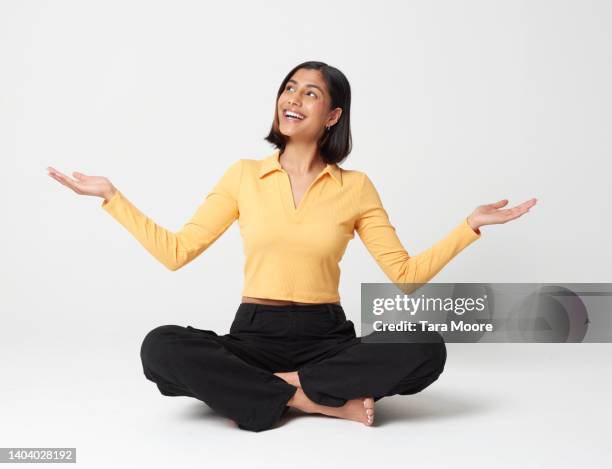 woman crossed legged with hands out - woman sitting cross legged stock pictures, royalty-free photos & images
