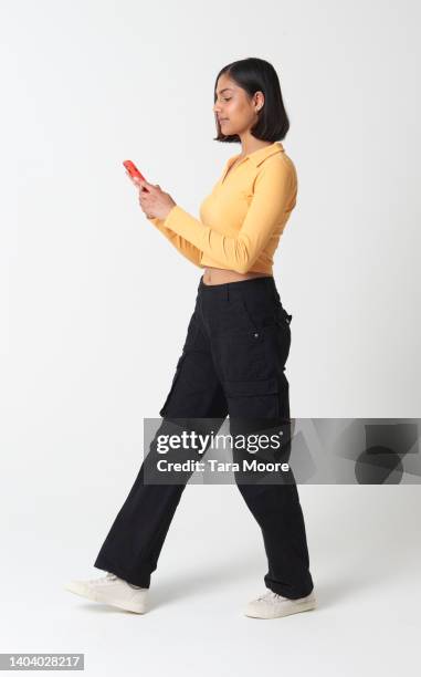 woman walking with phone - one person stockfoto's en -beelden