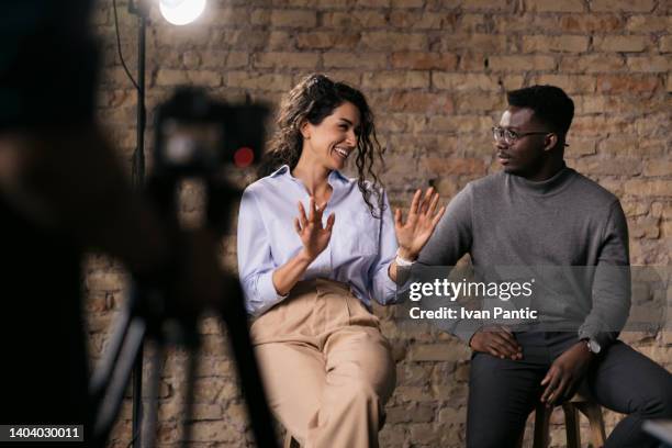 pareja diversa de modelos dando una entrevista en un estudio - actor photos fotografías e imágenes de stock