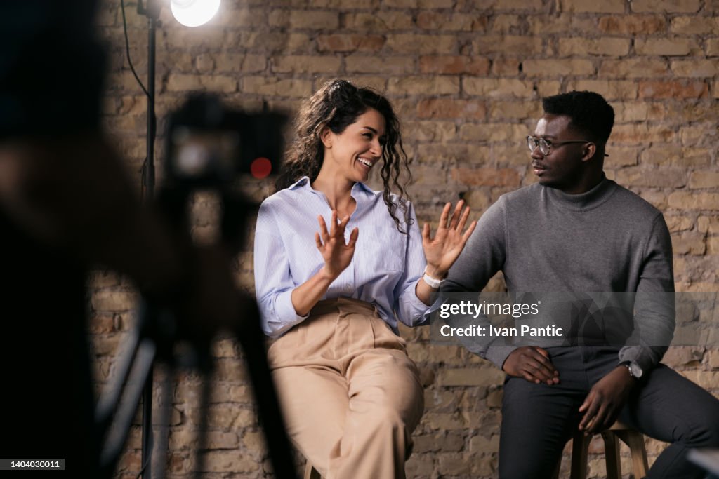 Diverse couple of models giving an interview in a studio