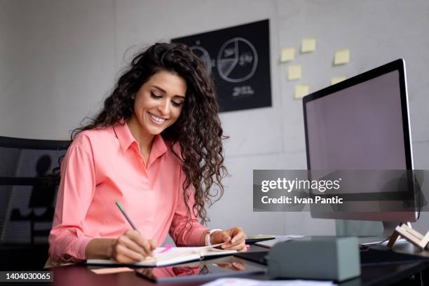 feliz empresaria trabajando cómodamente en su oficina - employee benefits fotografías e imágenes de stock