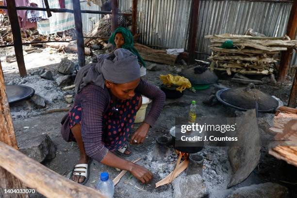 Woman from Wollega prepares food at a cooking station at the Children's Growing Center IDP camp on April 4, 2022 in Hayk, Ethiopia. The IDP camp...