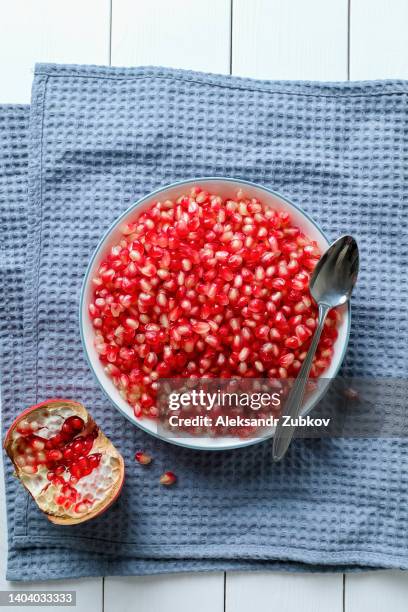 peeled pomegranate seeds in a plate, close-up. next to the unpeeled fruit in the peel. the concept of vegetarian, vegan and raw food. organic eco-friendly farm products, non-gmo. getting vitamins from nature. improving immunity. food background. - clear skin red background stock pictures, royalty-free photos & images